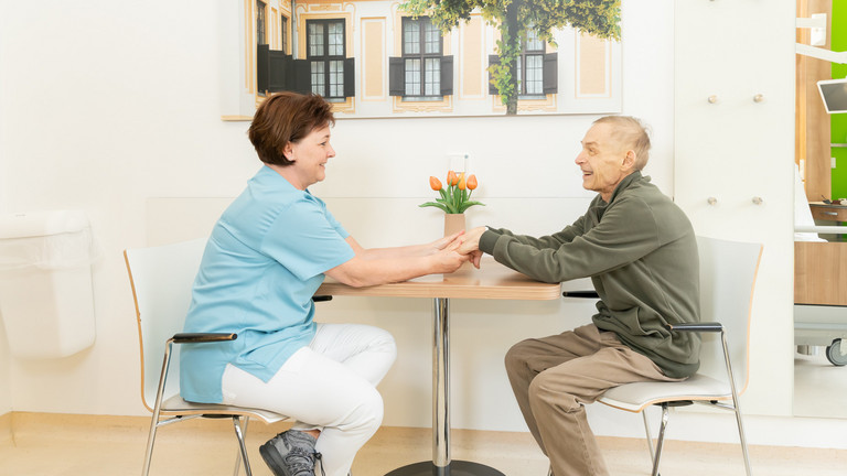 Pflegekraft mit Patient am Tisch - Palliativmedizin - Immanuel Klinik Rüdersdorf Pflegekraft mit Patient am Tisch - Palliativmedizin - Immanuel Klinik Rüdersdorf
