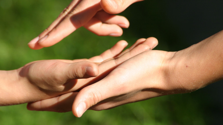 Eine menschliche Hand greift in eine andere und verdeutlicht den Wunsch nach Verständigung, Impuls zu Pfingsten, Klinikseelsorge, Theologie und Ethik, Immanuel Albertinen Diakonie Eine menschliche Hand greift in eine andere und verdeutlicht den Wunsch nach Verständigung