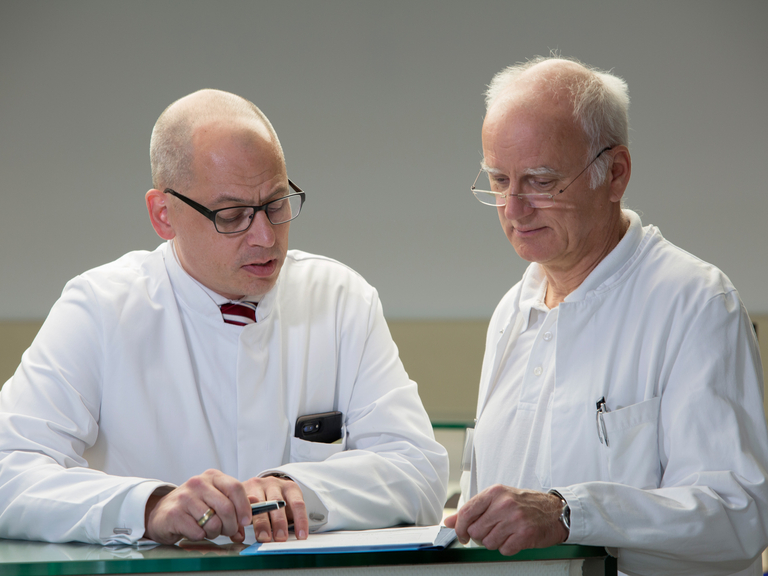 Zwei Ärzte schauen auf Formular - Immanuel Klinik Rüdersdorf bei Berlin