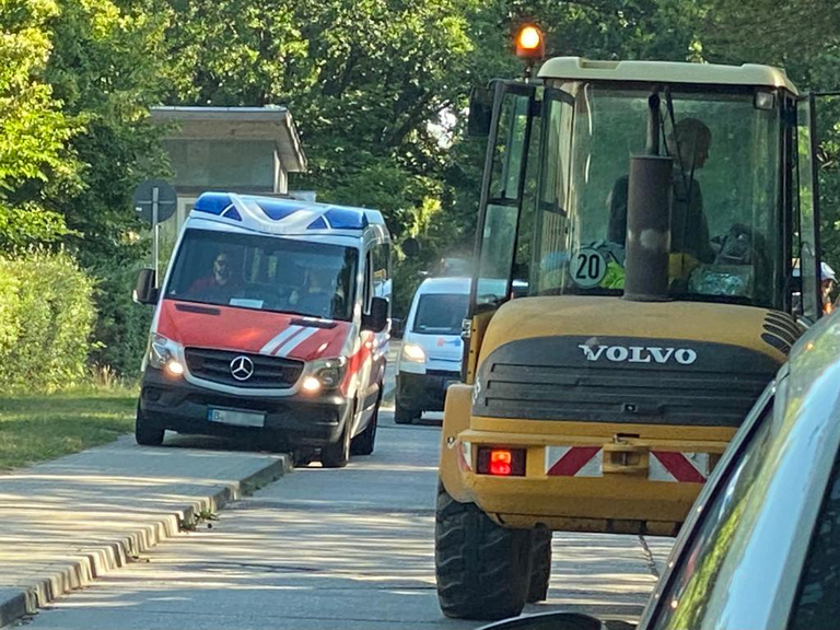 Ein Rettungswagen weicht einem Baufahrzeug bei Bauarabeiten in der Waldstraße in Rüdersdorf aus