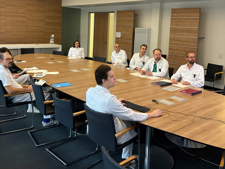 Ärzte sitzen bei der Morgenrunde um einen Konferenztisch - Alterstraumatologisches Zentrum