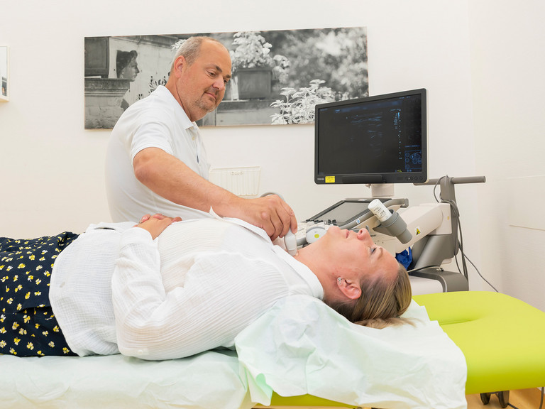 Arzt untersucht Patientin mit Ultraschall