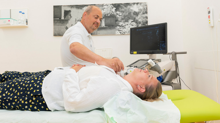 Arzt untersucht Patientin mit Ultraschall