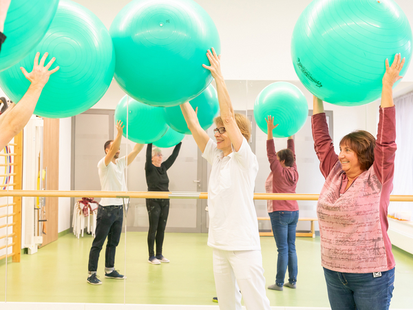 Gruppe führt Übung mit Gymnastikball aus - Physiotherapie - Immanuel Klinik Rüdersdorf