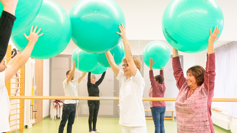 Gruppe übt mit Gymnastikball - Physiotherapie - Immanuel Klinik Rüdersdorf