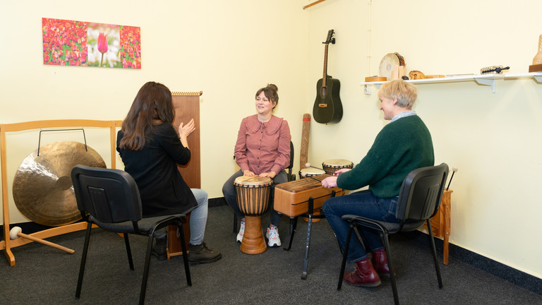 Drei Frauen sitzend im Kreis auf Stühlen mit Musikinstrumenten, Musiktherapie, Immanuel Klinik Rüdersdorf, Rüdersdorf bei Berlin