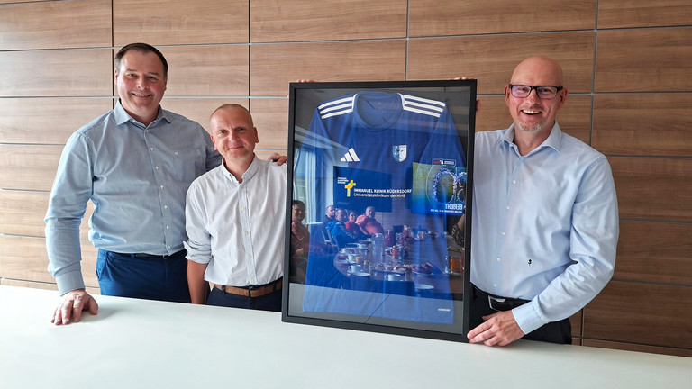 Vorstnadsmitglied des FC Strausber, Daniel Thamm und Frank Volkmer halten einen Bilderrahmen mit einem Trikot des FC Strausberg Vorstnadsmitglied des FC Strausber, Daniel Thamm und Frank Volkmer halten einen Bilderrahmen mit einem Trikot des FC Strausberg