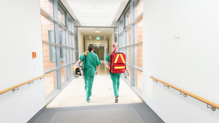 Zwei Pflegekräfte in Flur - Eine Person trägt Notfallrucksack - Anästhesiologie - Immanuel Klinik Rüdersdorf Zwei Pflegekräfte in Flur - Eine Person trägt Notfallrucksack - Anästhesiologie - Immanuel Klinik Rüdersdorf