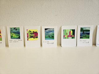 Mehrere kleine bunte gemalte Bilder mit motivierenden Sprüchen darunter aus der Kunsttherapie in der Immanuel Klinik Rüdersdorf