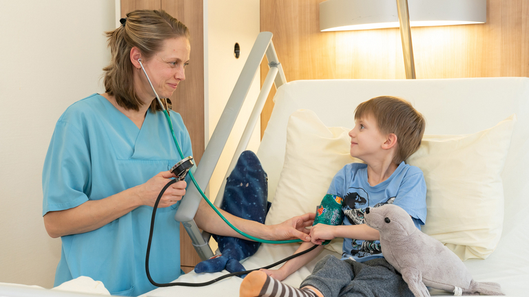 Pflegefachfrau misst Blutdruck bei Jungen - Immanuel Klinik Rüdersdorf bei Berlin - Altersgerechte Behandlung