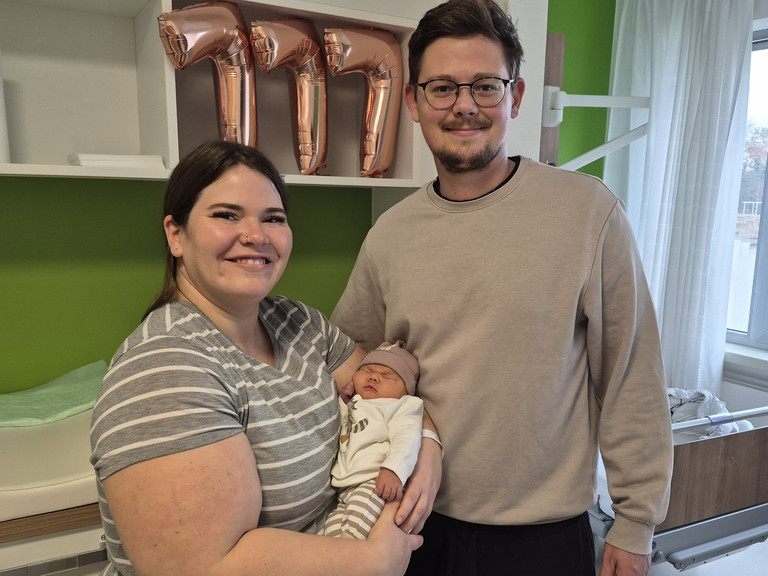 Hebamme mit Mutter, die das Baby im Arm hält und Vater in der Immanuel Klinik Rüdersdorf