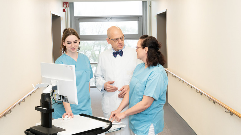 Arzt mit Pflegekräften im Gespräch an mobilen Visitenwagen - Anästhesiologie - Immanuel Klinik Rüdersdorf Arzt mit Pflegekräften im Gespräch an mobilen Visitenwagen - Anästhesiologie - Immanuel Klinik Rüdersdorf