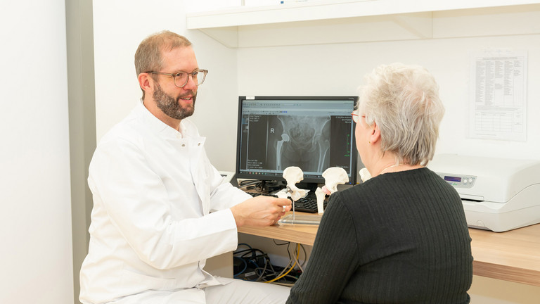 Arzt im Gespräch mit Patientin - Immanuel Klinik Rüdersdorf bei Berlin - Orthopädie - Durchgangsarzt